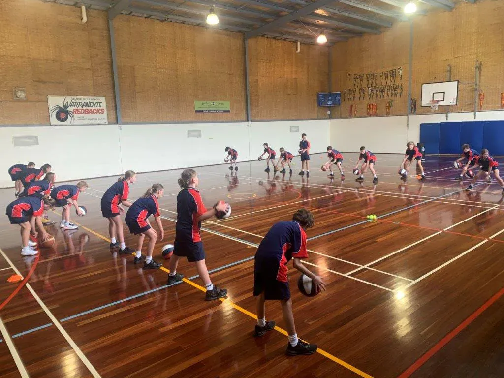 Inside the Warrandyte High School stadium, a Warrandyte Redbacks banner on the wall